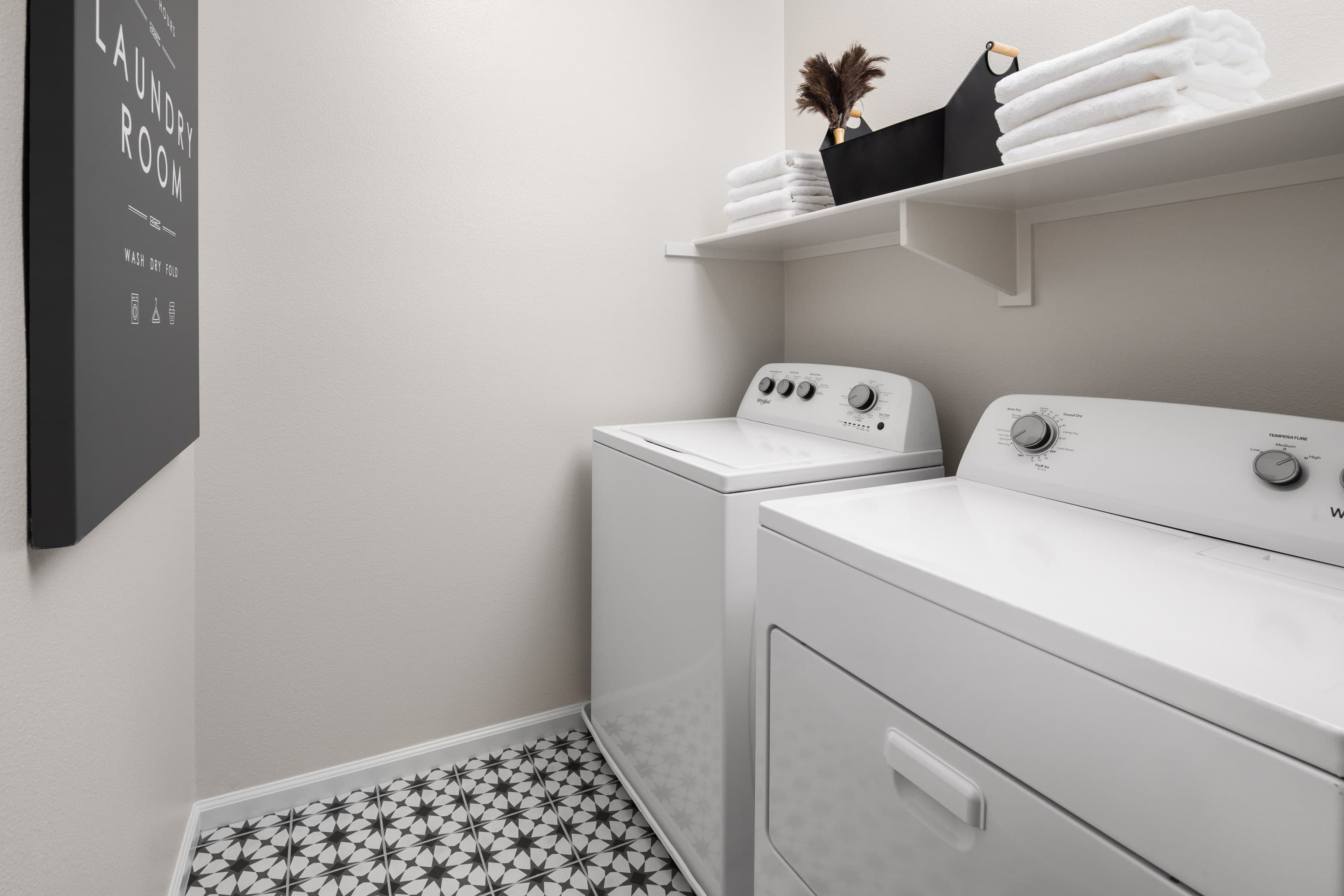 laundry room with geometric black tiles