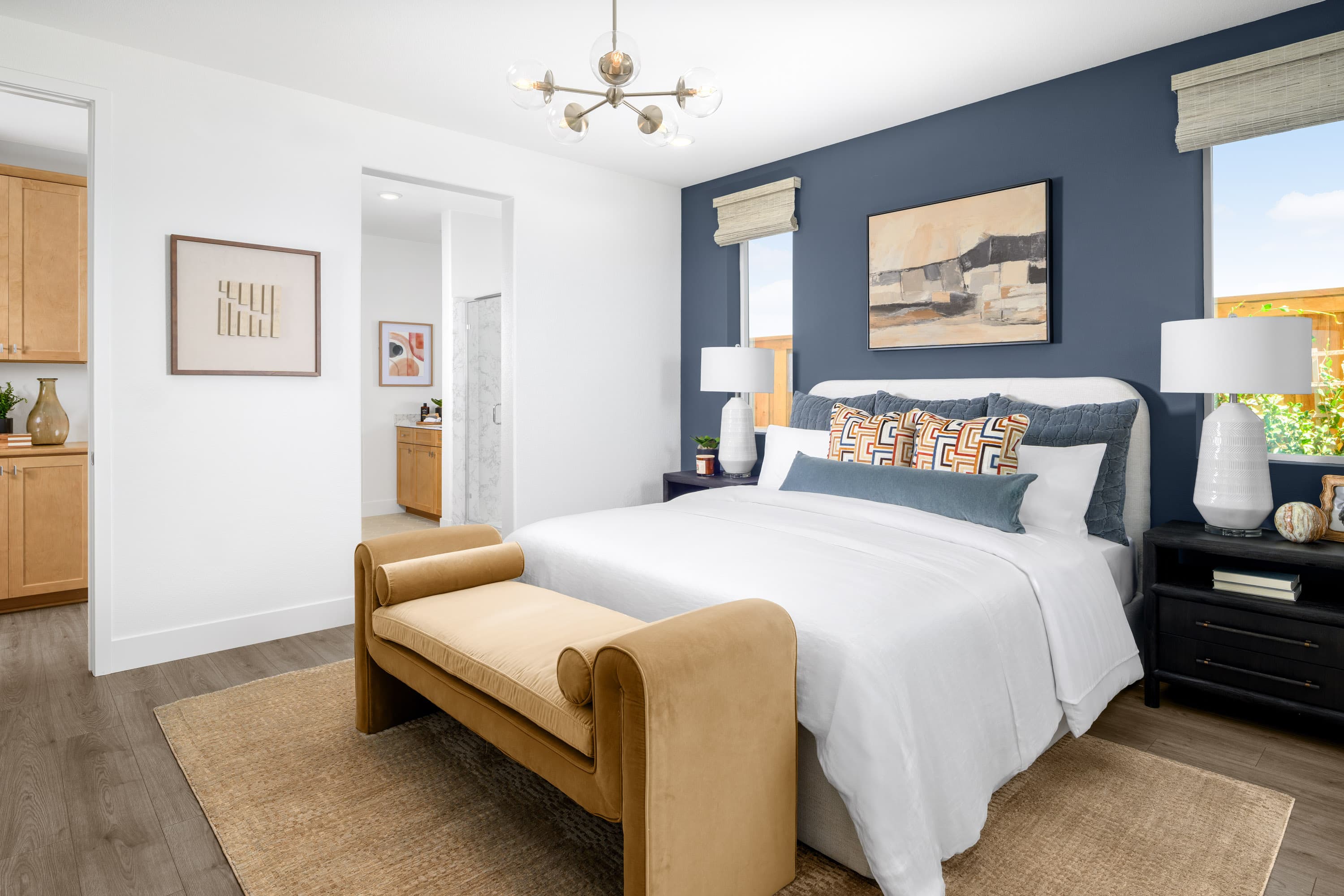 bedroom with blue accent wall & gold bench