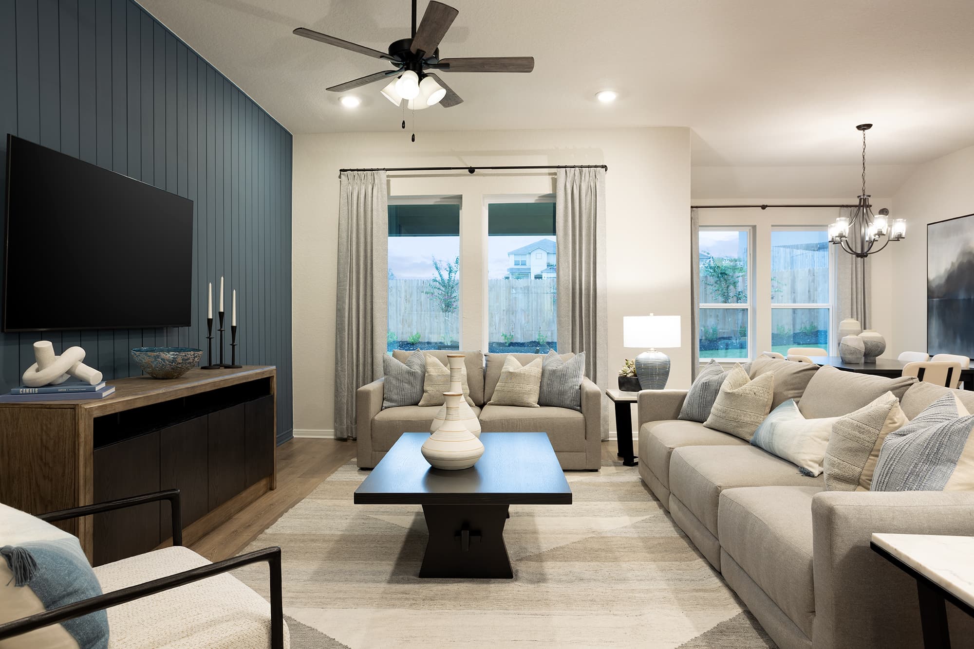 living room with a rug, couches & a ceiling fan