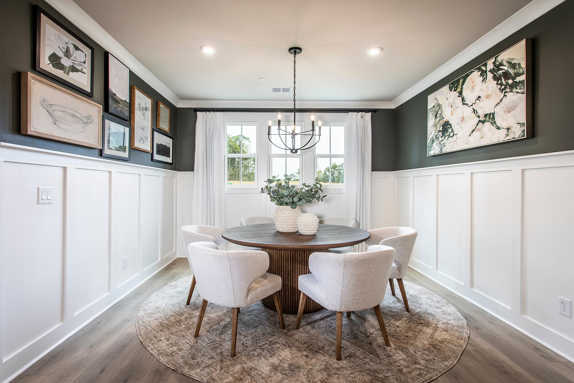 formal dining room with round table and wainscoting on the walls 