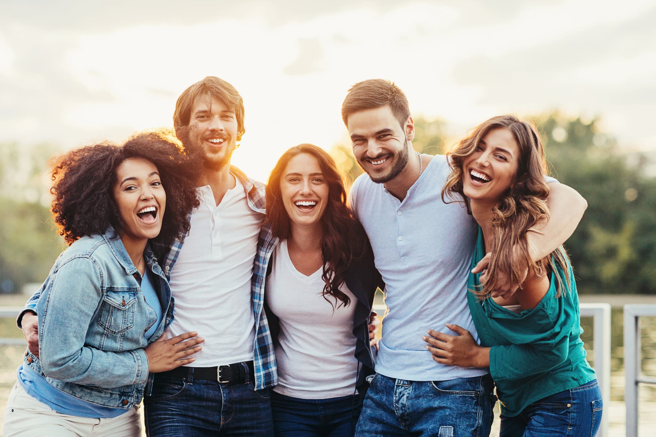 friends with their arms around each other smiling